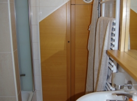 Studiowohnung - Herzmuschel Bad - Waschbecken, Blick auf die Abstellkammer und Dusche