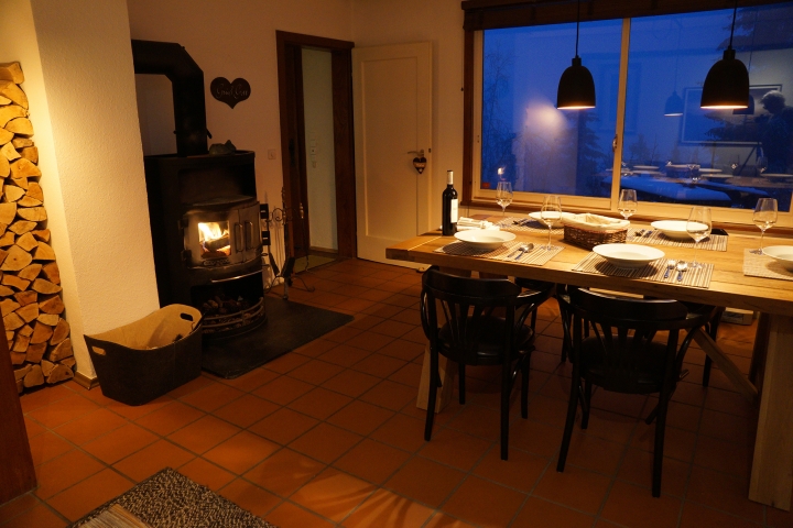 Wohzimmer mit massivem Holztisch und Sitzgruppe