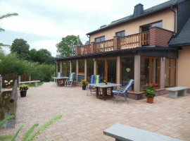 Rückseite des Hauses mit Blick auf die Wintergärten bzw. Gemeinschaftsraum und Terrasse mit Grillmöglichkeit 