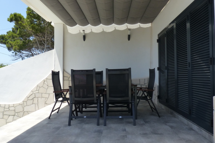 Terrasse mit Bestuhlung und Pergola als Sonnenschutz