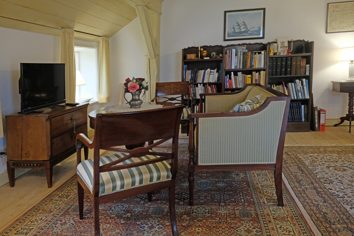 Im Wohnzimmer mit der Küche verbinden sich antike Möbel und moderne Technik