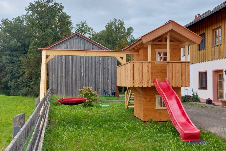 Spielhaus mit Schaukeln und Rutsche
