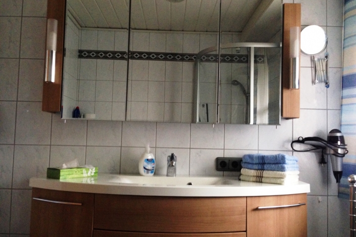 Bad mit Dusche, WC, Urinal und Schrankwand,
Fußbodenheizung und großes Fenster