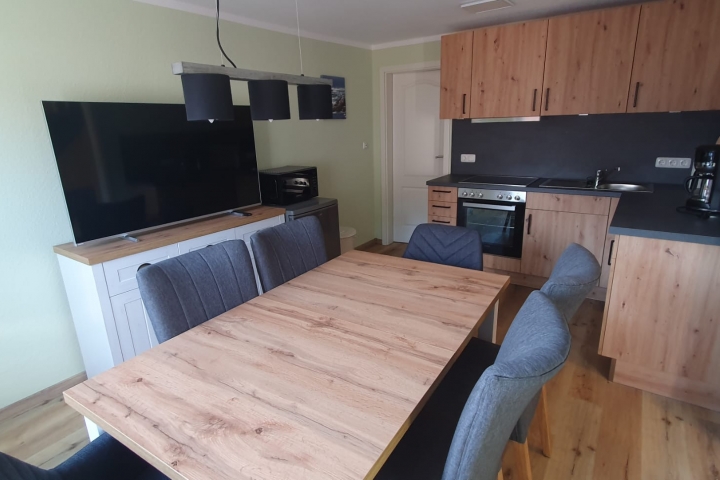 Voll ausgestattete Küche mit Geschirrspüler und gemütlicher Sitzgruppe und Ambilight TV