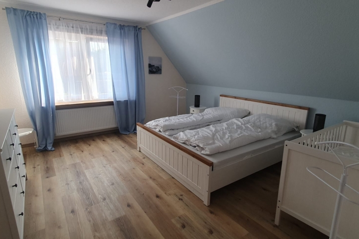 Elternschlafzimmer mit Kleinkinderbett und Ambilight TV