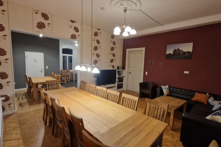 Wohnzimmer EG mit modernem Durchbruch zur Küche und Esstische für bis zu 18 Personen. Ecksofa mit TV