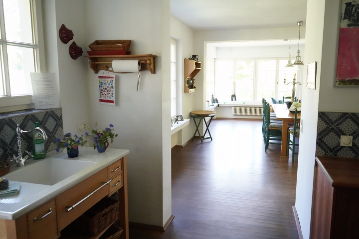 Blick von der Spülküche ins Esszimmer mit Esstisch und Herd