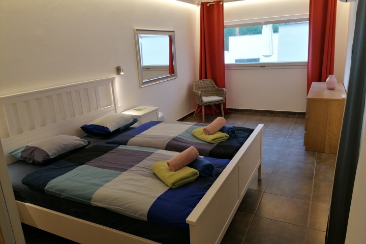 Schlafzimmer mit Fenster zum Pool.
