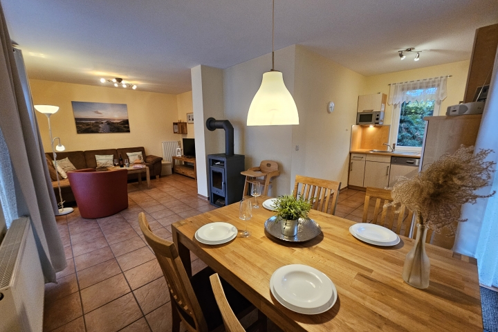 Wohnzimmer mit Kamin und offener Küche
