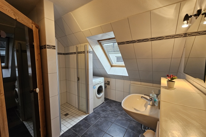 Bad mit Dusche, Waschmaschine und Sauna im Obergeschoß
