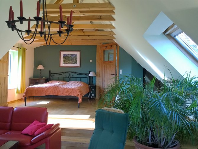 Ferienwohnung Villa Grieß | großes Wohnschlafzimmer mit Doppelbett und Sitzbereich, drei Stufen über die gesamte Raumbreite