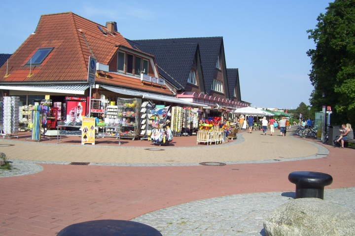 Die Strandpromenade in Sahlenburg, mit Geschäften, Eisdiele, Fischimbiss, verschiedenen Lokalen, Bäckerei und Kneipen.
