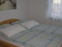 Schlafzimmer 1 mit Doppelbett in Komforthöhe und Kleiderschrank