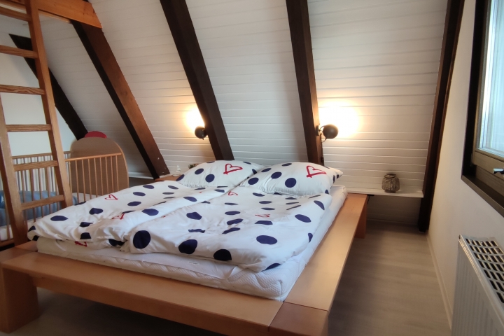 Großes Schlafzimmer mit Kinderbett im 1. OG