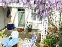 1 Zi. Wohng. Terrasse mit Pergola im Frühsommer