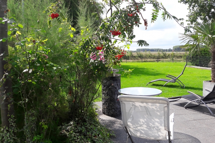 Terrasse mit Grillstation und das feinmaschig eingezäunte Grundstück