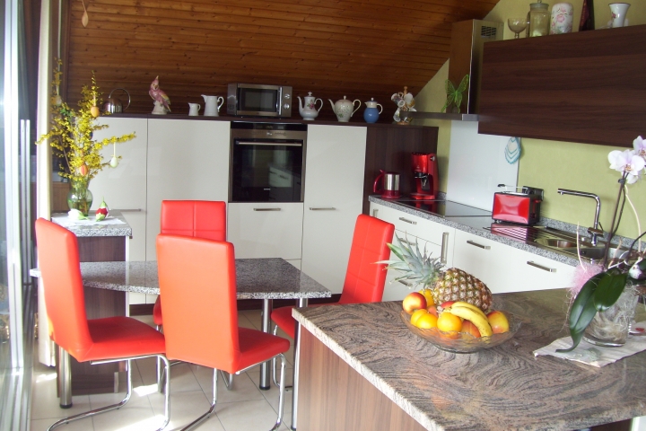 Die exclusive, helle und offene Wohnküche mit Insel und Granitarbeitsplatten.