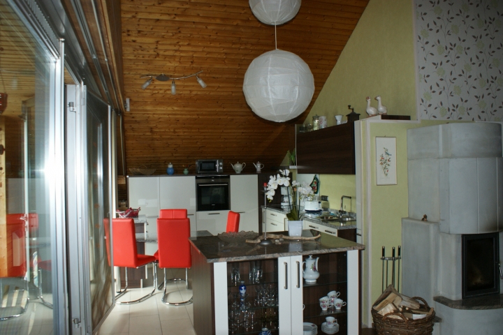 Blick vom Wohnraum in die offene Küche mit sämtlichen E- Geräten ausgestattet.