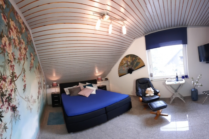Das Elternschlafzimmer hat ein großes Fenster mit Fliegengitter und Verdunklungsrollo.