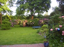 Ein Garten, wie ein Park mit Liegewiese und vielen seltenen Pflanzen, mehreren Terrassen und Sitzplätzen, Stühlen u. Liegestühlen.