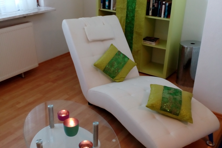 Relaxbereich im Schlafzimmer mit Fitnessgerät und Liege.