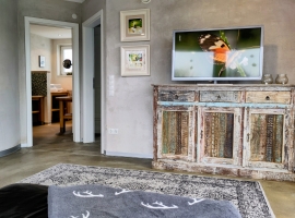 Fernsehschrank mit Smart-TV und Eingang zum Schlafzimmer und Badezimmer.