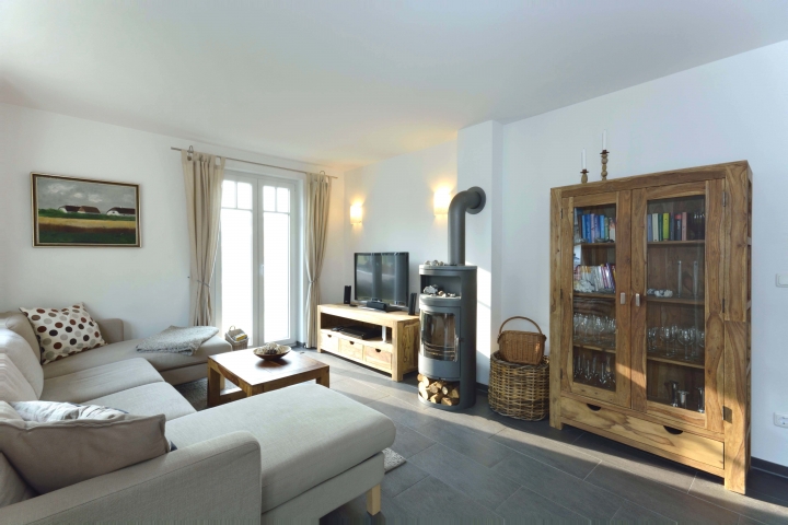 Sofa mit Bücherschrank, Kamin und TV.