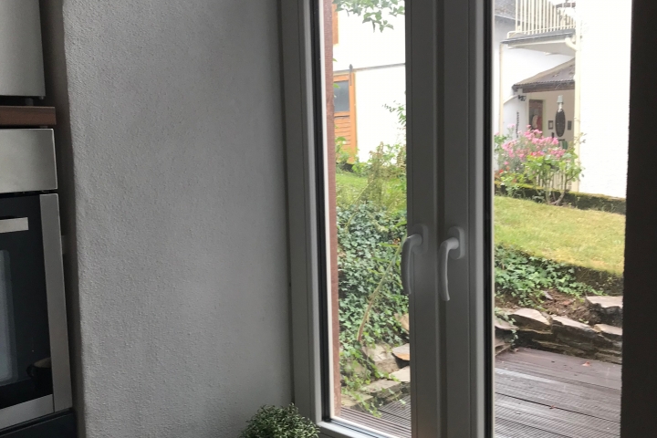 Blick aus Küchenfenster auf Terrasse und Gartenanteil