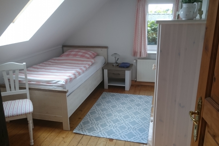 Schlafzimmer mit Einzelbett und Schrank