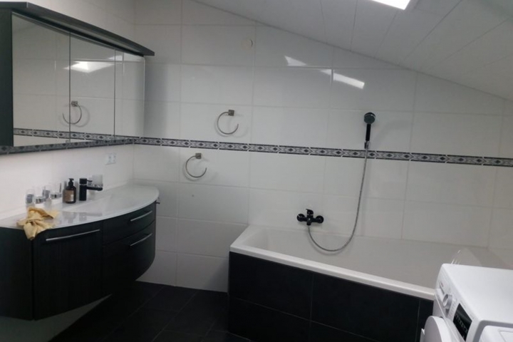 modernes Bad mit Badewanne und moderner Dusche Waschmaschine und Trockner