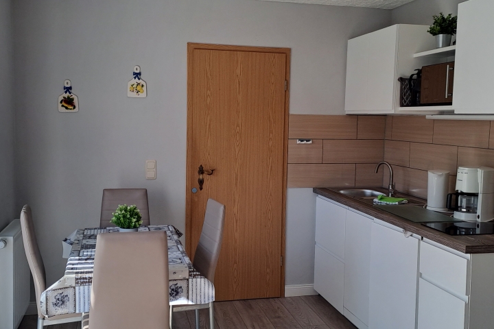 Küche mit Kühlschrank, Geschirrspüler, Mikrowelle, Kaffeemaschine, Wasserkocher und Küchengeschirr