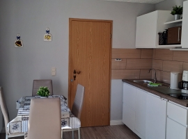 Küche mit Kühlschrank, Geschirrspüler, Mikrowelle, Kaffeemaschine, Wasserkocher und Küchengeschirr