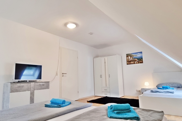 Schlafzimmer mit einem Doppel und einem Einzelbett mit TV