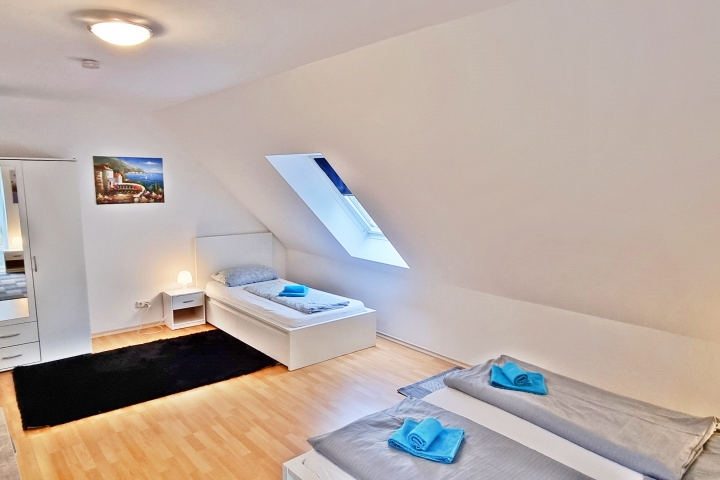 Schlafzimmer mit einem Doppel und einem Einzelbett mit TV