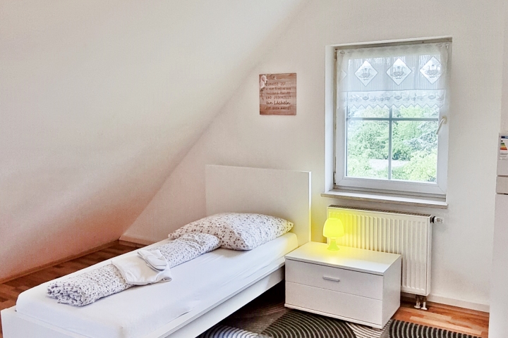 Schlafzimmer im Obergeschoss mit 2 Einzelbetten und TV