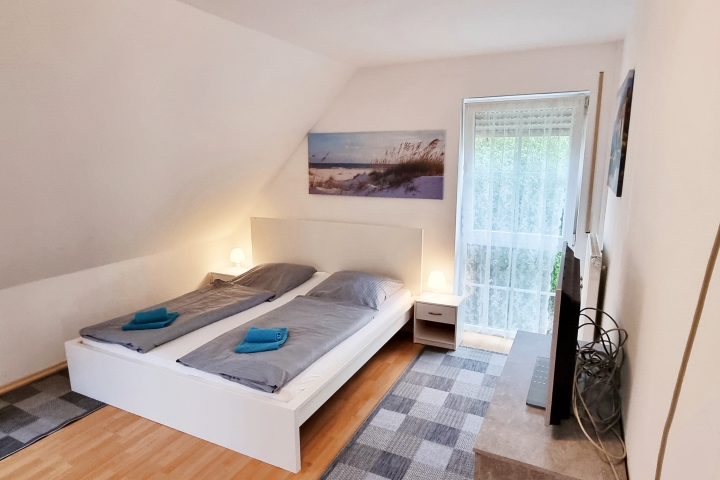 Schlafzimmer mit einem Doppel und einem Einzelbett mit TV