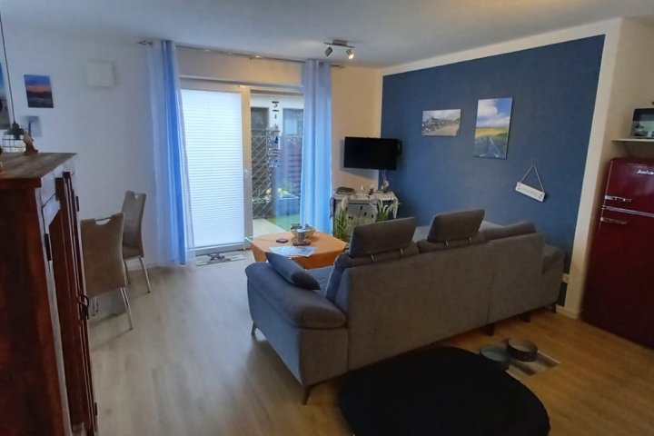 Wohnbereich der Ferienwohnung Slumpschööt mit TV und Ecksofa