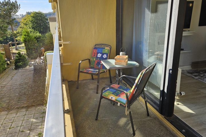 Sonniger Südbalkon mit bequemen Stühlen und Tisch – perfekt für entspannte Stunden im Freien.