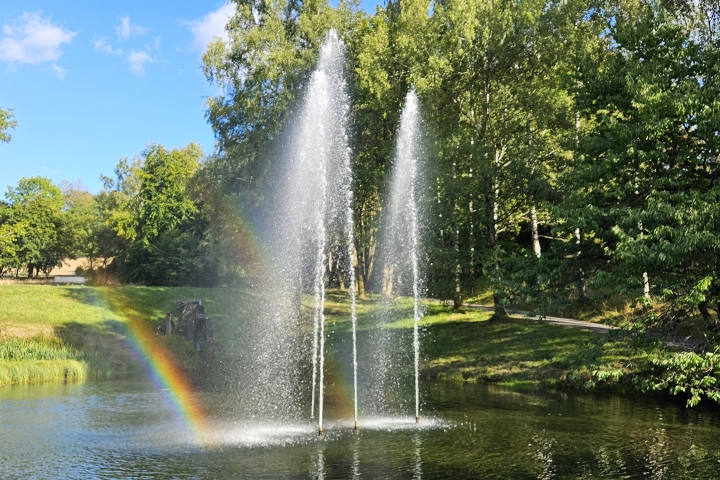 Idyllischer Springbrunnen mit Wasserrad direkt vor der Tür – ein Ort der Ruhe und Erholung.