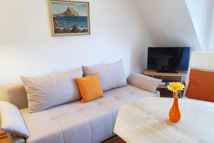 Wohnraum mit Schlafsofa und Ausgang zum Balkon