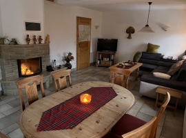 Wohnzimmer vom Esstisch aus mit Blick zum brennenden Kamin